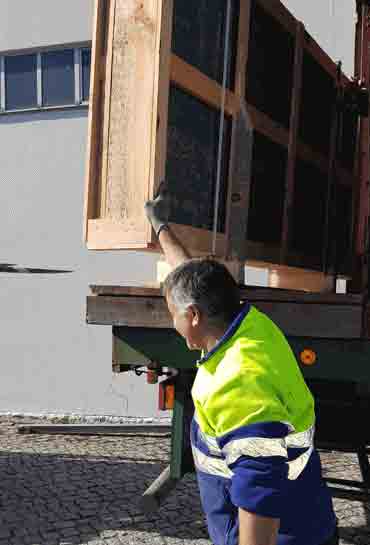 Worker unloading Porto VALONGO BLACK™ slate slabs in wooden crate for stone import and distribution